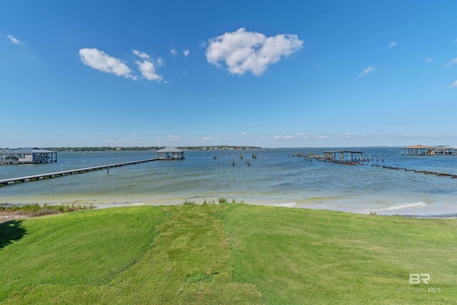 dock area featuring a lawn and a water view