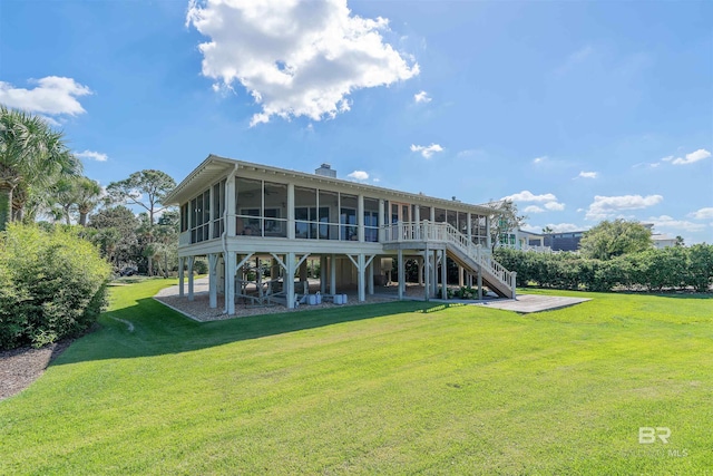 rear view of property featuring a yard, a patio area, and a sunroom