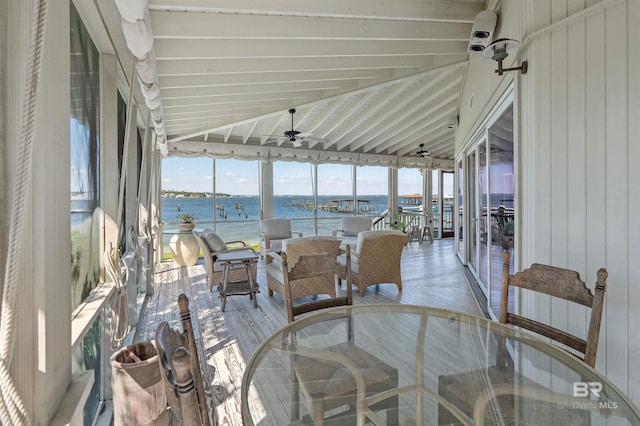 sunroom / solarium featuring a water view and ceiling fan