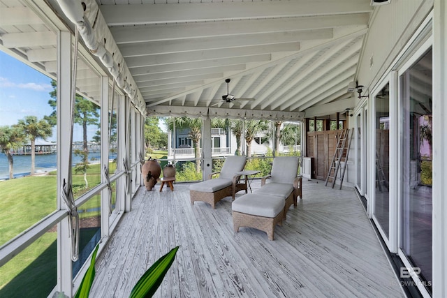 unfurnished sunroom featuring lofted ceiling with beams and a water view