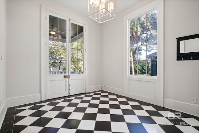 doorway to outside with a wealth of natural light and a chandelier