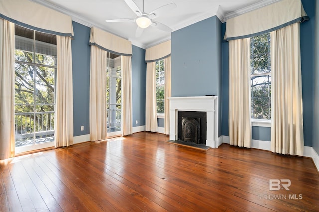 unfurnished living room featuring ceiling fan, a healthy amount of sunlight, ornamental molding, and dark hardwood / wood-style floors