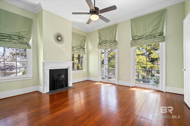 unfurnished living room featuring a healthy amount of sunlight, ornamental molding, and wood-type flooring