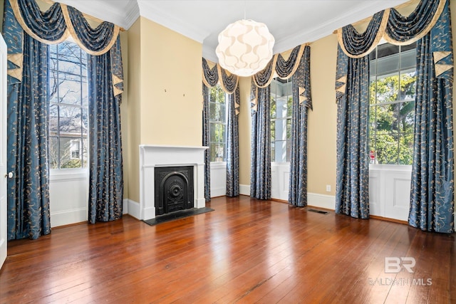 unfurnished living room featuring crown molding, dark hardwood / wood-style floors, and a healthy amount of sunlight