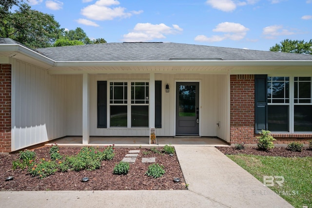 602 W 4th St, Bay Minette, AL 36507 - property entrance with a porch, brick siding, and roof with shingles