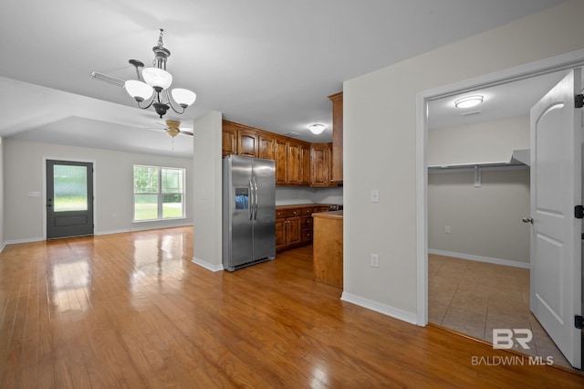 602 W 4th St, Bay Minette, AL 36507 - kitchen with stainless steel fridge, brown cabinetry, light wood finished floors, and baseboards