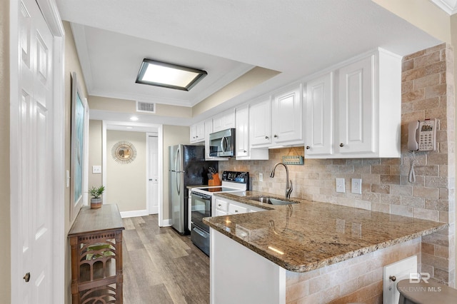 969 W Beach Blvd Unit 1306, Gulf Shores, AL 36542 - kitchen with appliances with stainless steel finishes, a sink, wood finished floors, stone counters, and white cabinetry