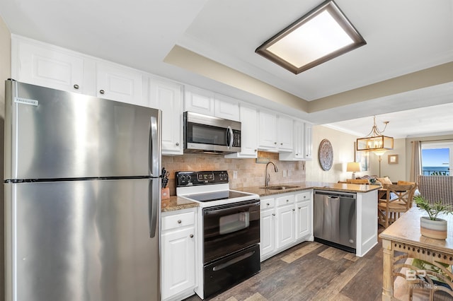 969 W Beach Blvd Unit 1306, Gulf Shores, AL 36542 - kitchen featuring stainless steel appliances, a sink, white cabinets, dark wood finished floors, and a peninsula