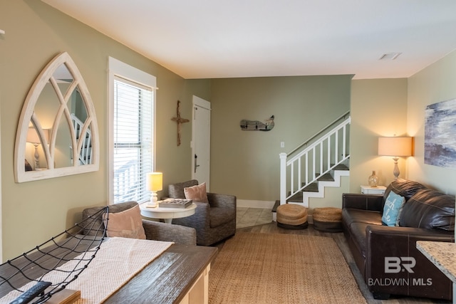 tiled living area featuring visible vents and stairs