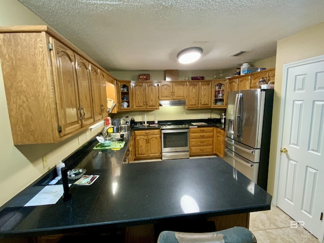 kitchen featuring sink, light tile patterned floors, a textured ceiling, and appliances with stainless steel finishes