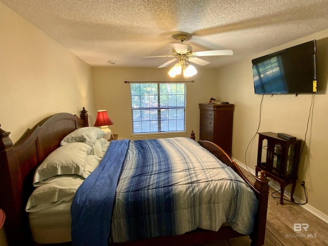 bedroom featuring a textured ceiling, hardwood / wood-style flooring, and ceiling fan