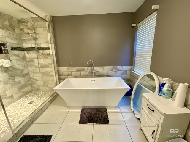 bathroom with shower with separate bathtub and tile patterned floors