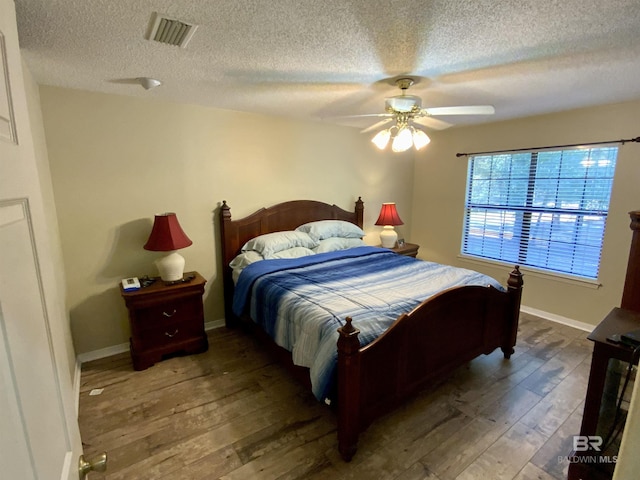 bedroom with hardwood / wood-style flooring, ceiling fan, and a textured ceiling