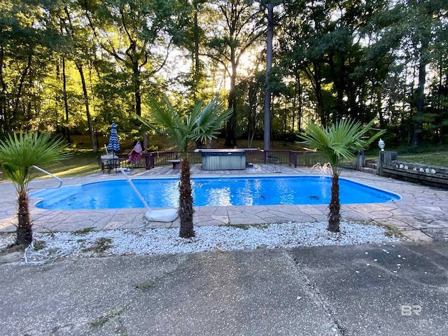 view of swimming pool with a hot tub