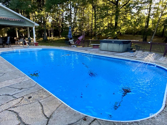 view of pool with a hot tub