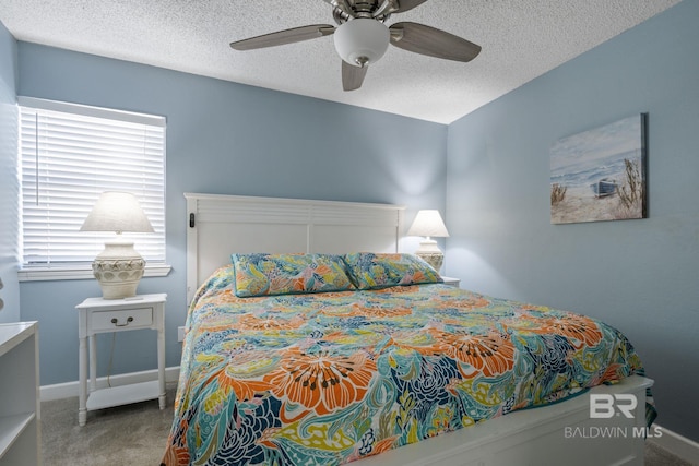 bedroom featuring ceiling fan, a textured ceiling, and carpet flooring