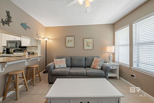 tiled living room featuring ceiling fan and a textured ceiling