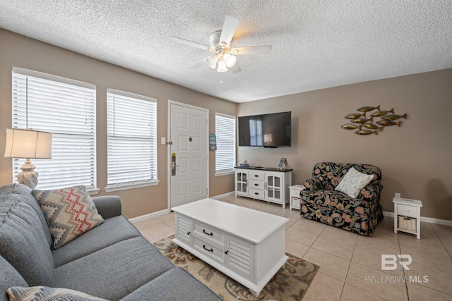 living room with a textured ceiling, light tile patterned floors, and ceiling fan