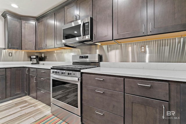 kitchen featuring dark brown cabinets, light hardwood / wood-style floors, and stainless steel appliances