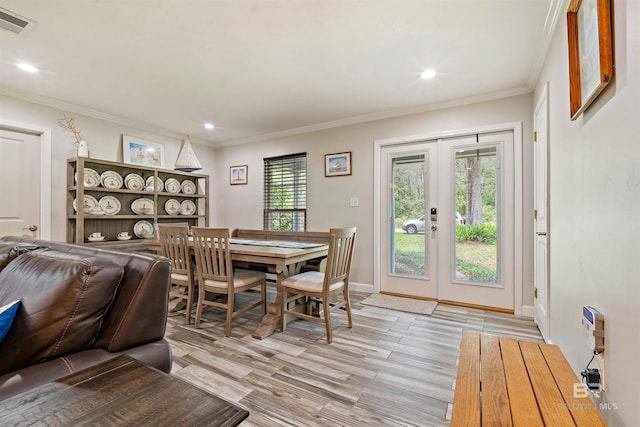 dining space with french doors, ornamental molding, and light hardwood / wood-style floors