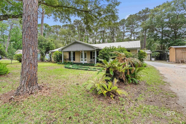 single story home featuring covered porch and a front yard