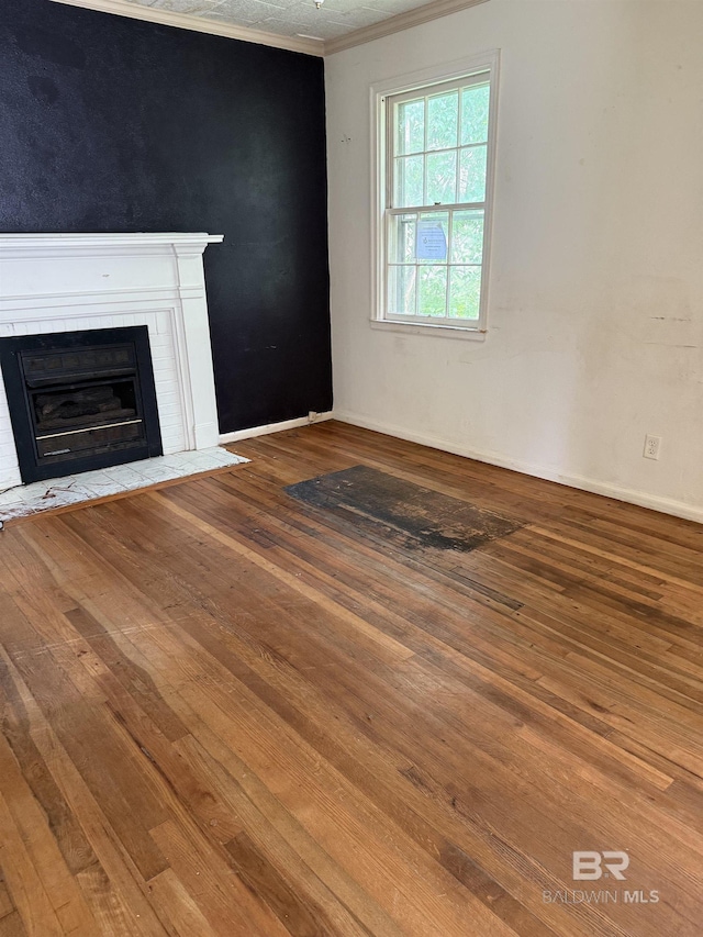502 E Myrtle Ave, Foley, AL 36535 - unfurnished living room with hardwood / wood-style flooring, ornamental molding, and a fireplace with flush hearth