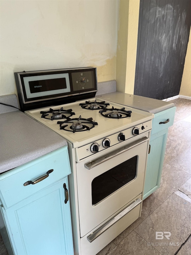 502 E Myrtle Ave, Foley, AL 36535 - kitchen featuring white range with gas cooktop, light countertops, and blue cabinetry