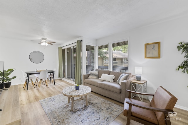 2086 N Seacliff Dr Unit 2086, Daphne, AL 36526 - living area featuring a textured ceiling, ceiling fan, light wood-style flooring, and baseboards