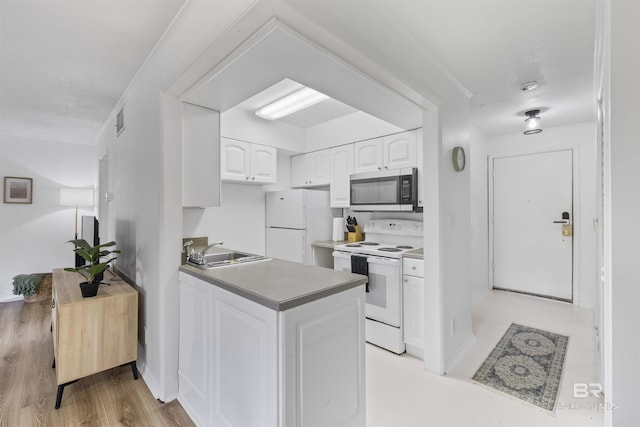 2086 N Seacliff Dr Unit 2086, Daphne, AL 36526 - kitchen with white appliances, a sink, white cabinets, a peninsula, and light wood-style floors
