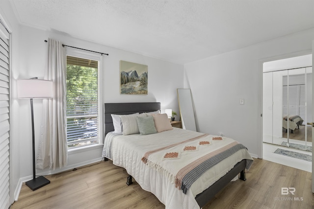 2086 N Seacliff Dr Unit 2086, Daphne, AL 36526 - bedroom featuring light wood-style floors, baseboards, and a textured ceiling