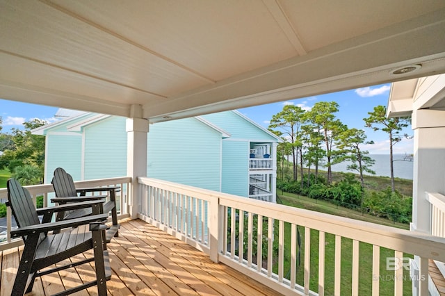 wooden terrace featuring a lawn