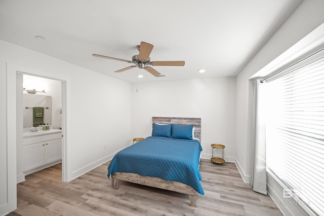 bedroom with light wood-style flooring, baseboards, connected bathroom, and recessed lighting