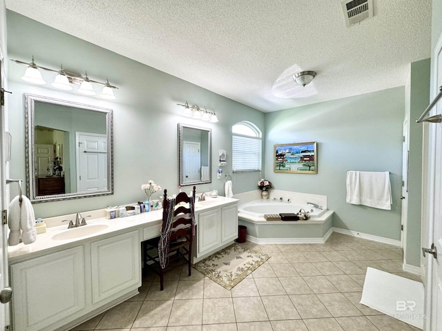 22835 County Road 12, Foley, AL 36535 - bathroom featuring tile patterned flooring, double vanity, a garden tub, and a textured ceiling