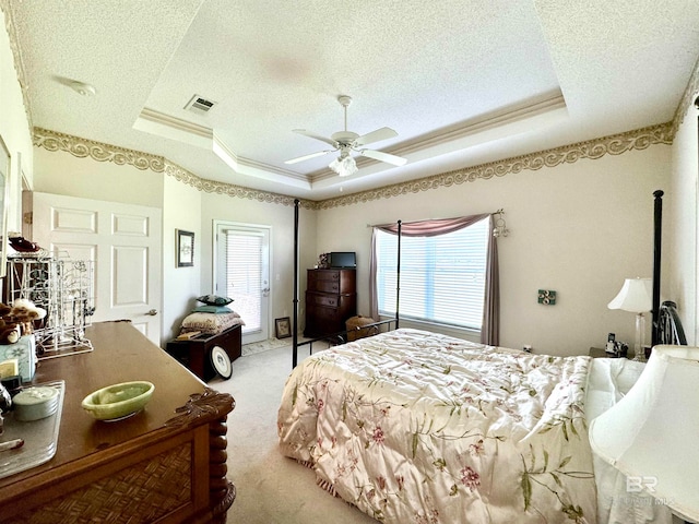 bedroom featuring light carpet, a tray ceiling, and multiple windows