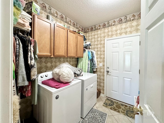 washroom with separate washer and dryer, cabinets, a textured ceiling, and light tile patterned flooring