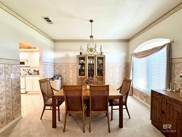 22835 County Road 12, Foley, AL 36535 - dining room with a chandelier, a wainscoted wall, a textured ceiling, light carpet, and wallpapered walls