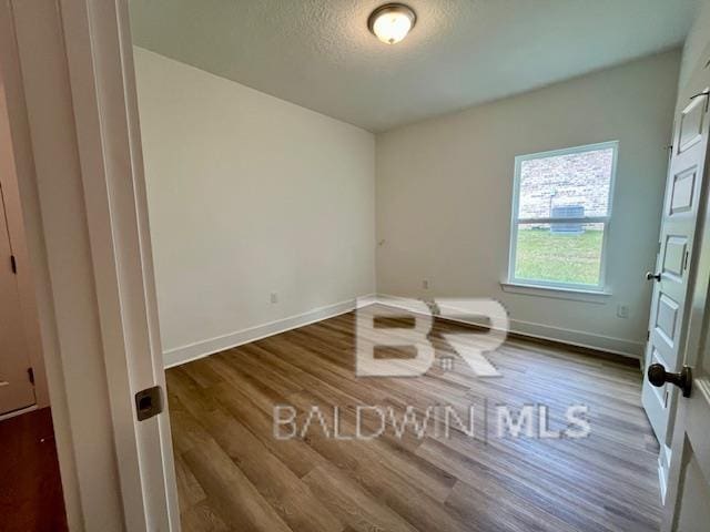 spare room with hardwood / wood-style flooring and a textured ceiling