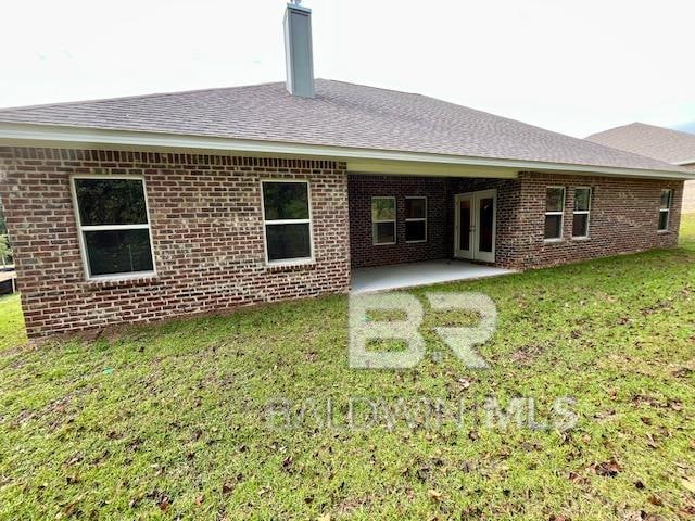 rear view of property with a lawn and a patio area