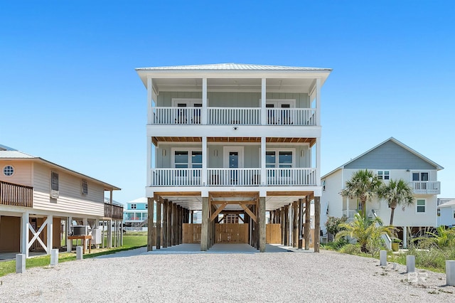 1337 W Lagoon Ave, Gulf Shores, AL 36542 - coastal home featuring driveway, a carport, covered porch, and board and batten siding