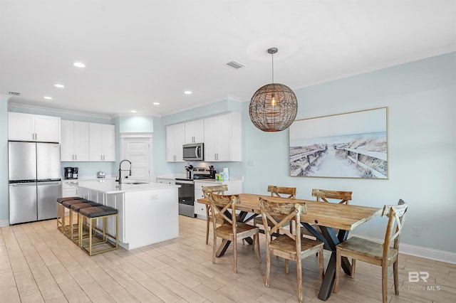 1337 W Lagoon Ave, Gulf Shores, AL 36542 - kitchen featuring visible vents, stainless steel appliances, an island with sink, light wood-type flooring, and an inviting chandelier