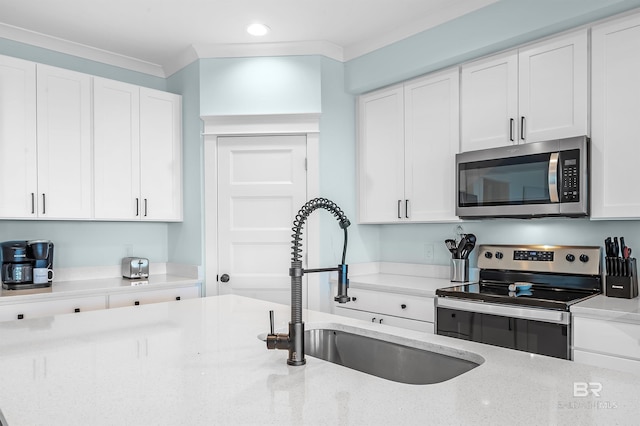 1337 W Lagoon Ave, Gulf Shores, AL 36542 - kitchen with white cabinetry, a sink, stainless steel appliances, and light stone countertops