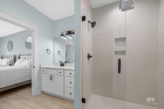 1337 W Lagoon Ave, Gulf Shores, AL 36542 - ensuite bathroom featuring a shower stall, connected bathroom, vanity, and wood finish floors
