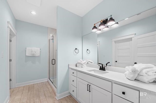 1337 W Lagoon Ave, Gulf Shores, AL 36542 - bathroom featuring a stall shower, baseboards, wood finished floors, and vanity