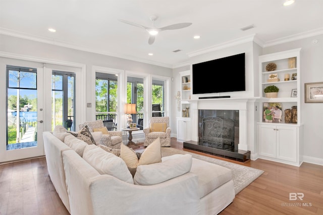 living room with ceiling fan, light hardwood / wood-style floors, and ornamental molding