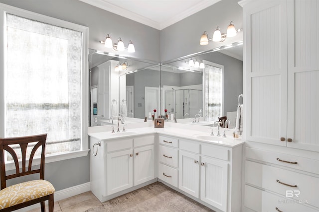 bathroom featuring tile patterned floors, vanity, a shower with shower door, and crown molding