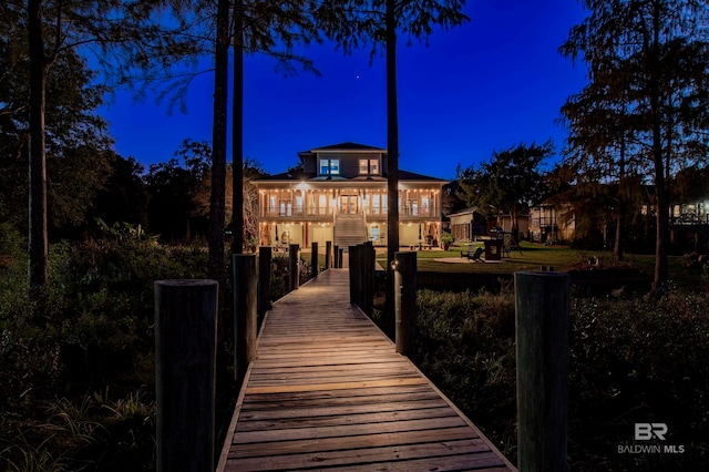 back house at twilight featuring a balcony