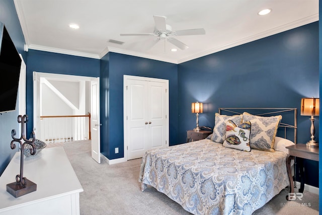 carpeted bedroom featuring ceiling fan, crown molding, and a closet