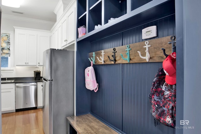 mudroom with wood-type flooring and ornamental molding