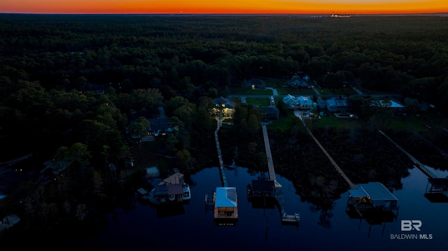 aerial view at dusk featuring a water view