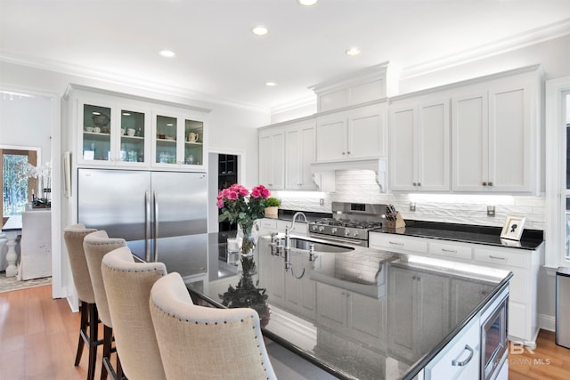 kitchen featuring white cabinets, light hardwood / wood-style floors, sink, and stainless steel appliances